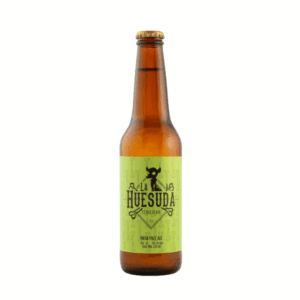 Botella de cerveza artesanal La Huesuda India Pale Ale de 355 ml, etiqueta verde con diseño de calavera sobre fondo blanco.